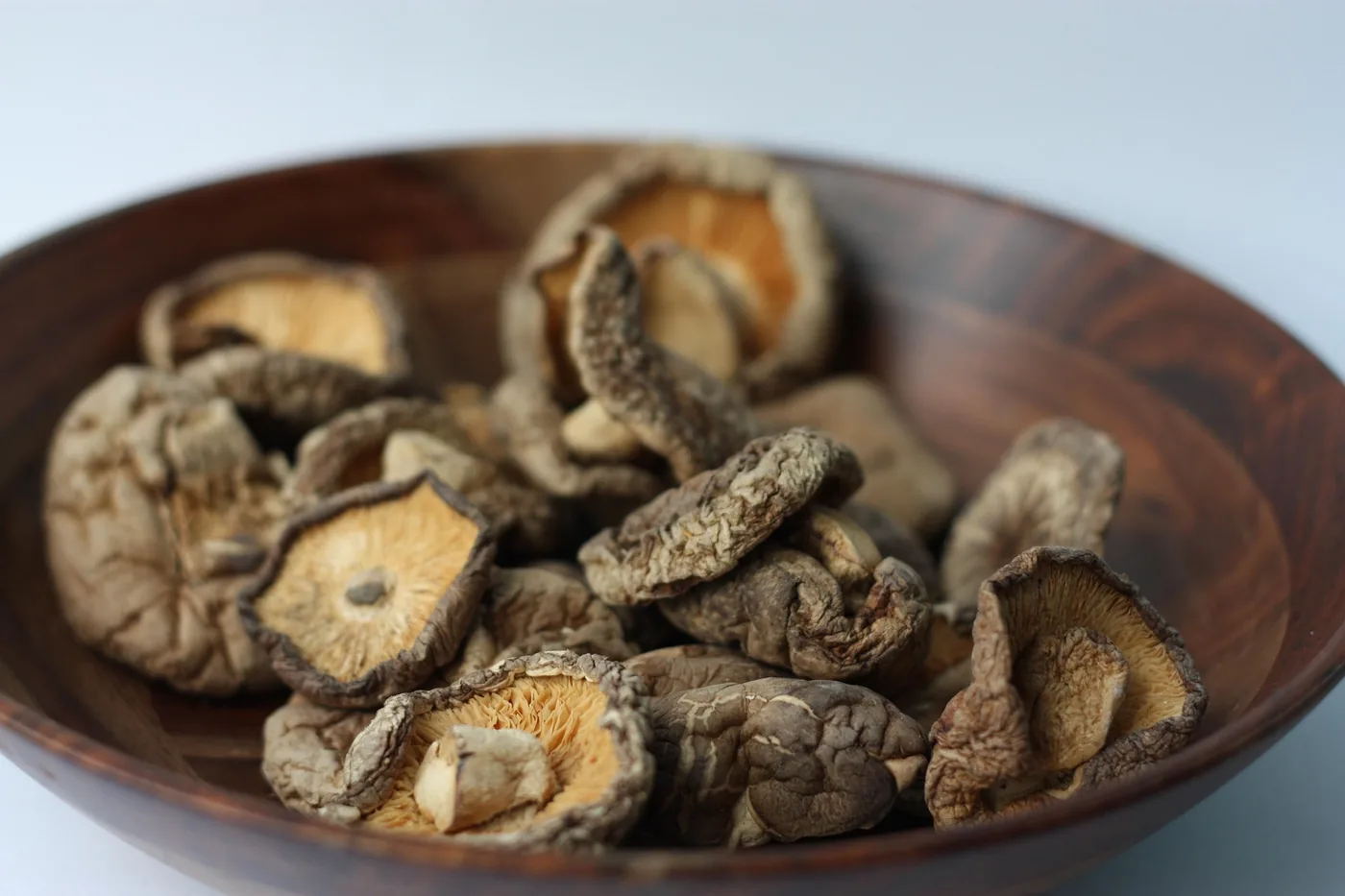Dried medicinal mushrooms arranged in a wooden bowl
